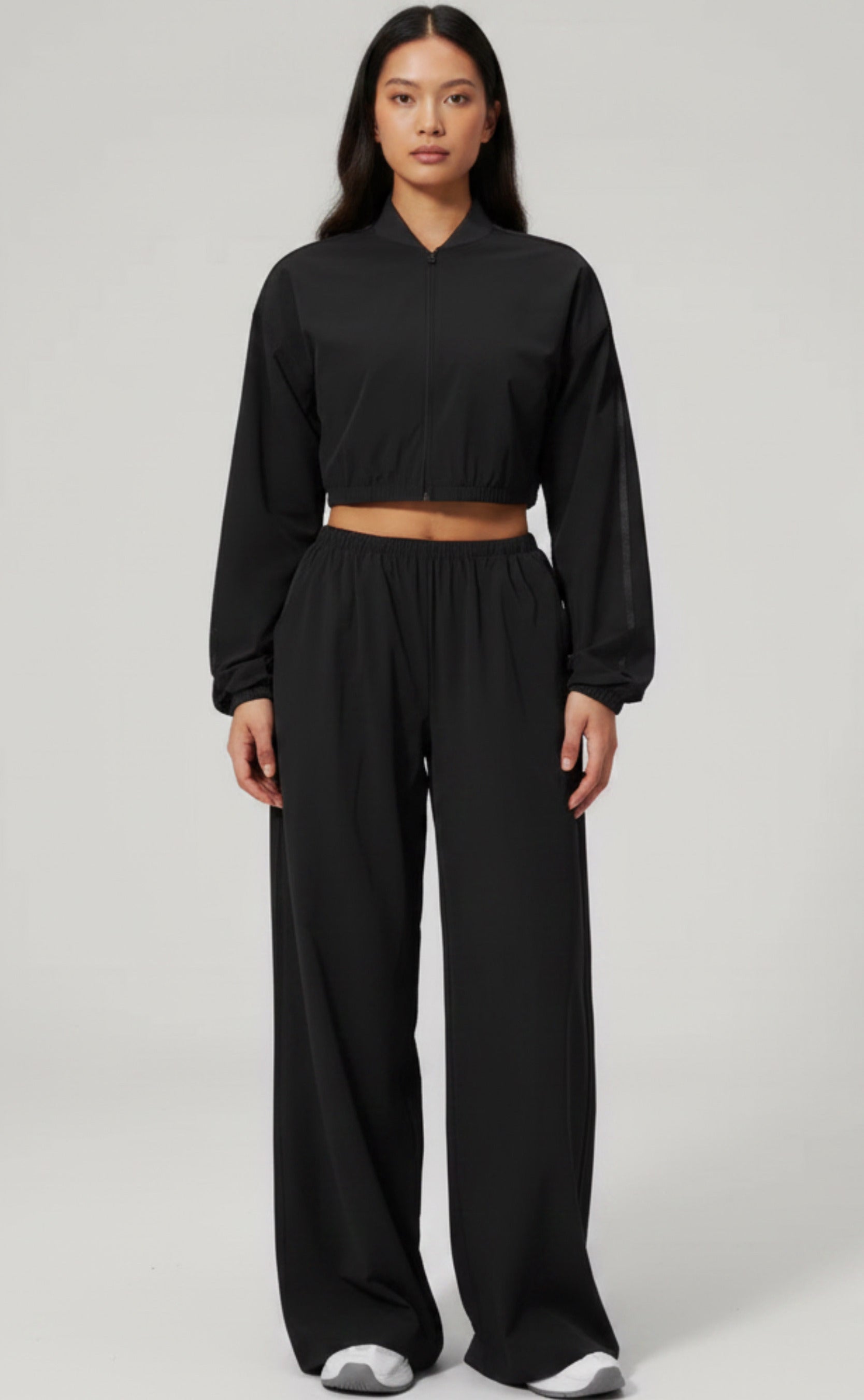 Person wearing a black outfit on a plain background
