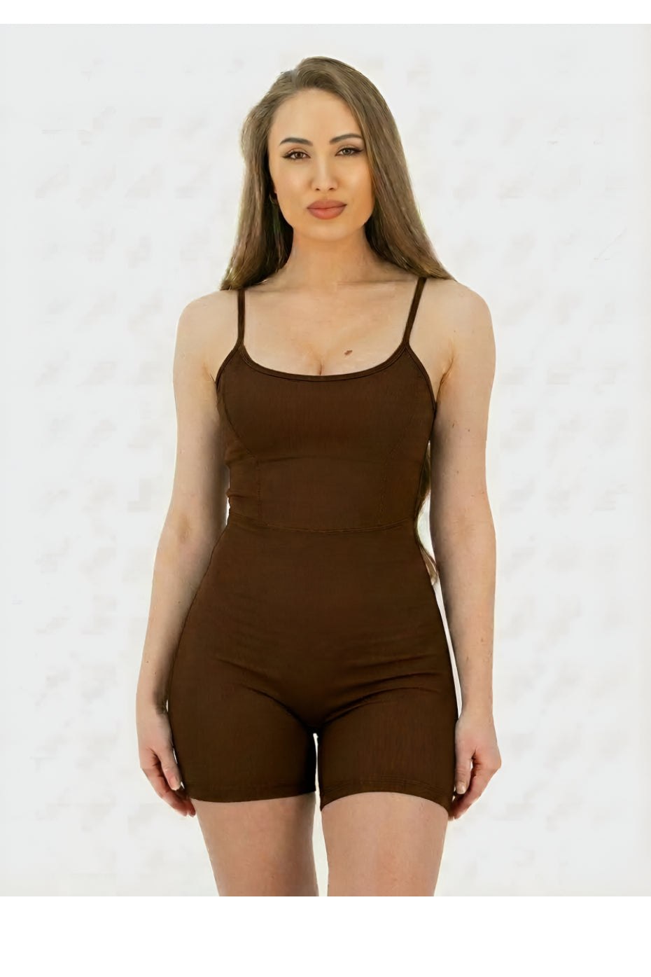 Woman wearing a brown bodysuit against a white background