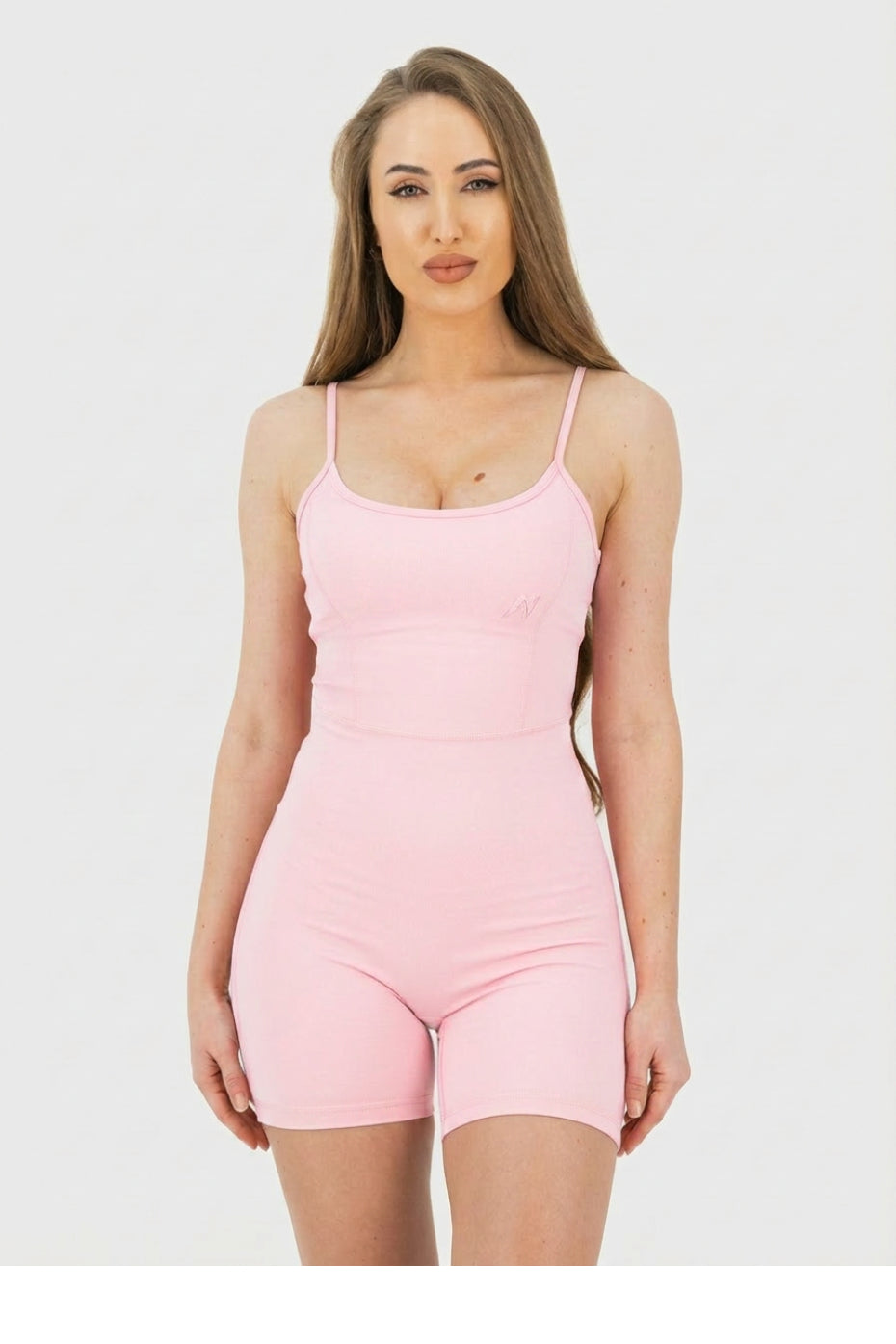Woman wearing a pink bodysuit against a white background